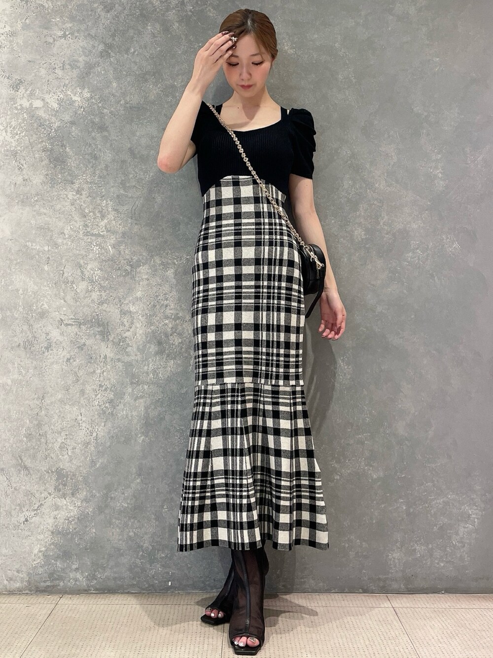 ブラック系のショルダーバッグ、ブラック系のワンピース、ブラック系のブーツを着用したレディースの夏コーディネートの2枚目の写真