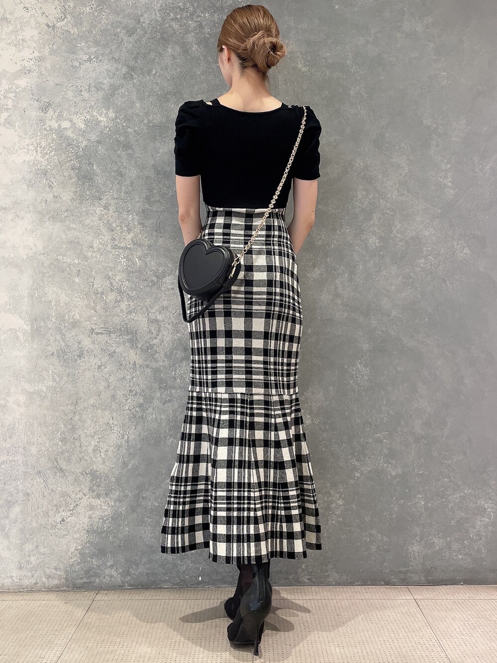 ブラック系のショルダーバッグ、ブラック系のワンピース、ブラック系のブーツを着用したレディースの夏コーディネートの4枚目の写真