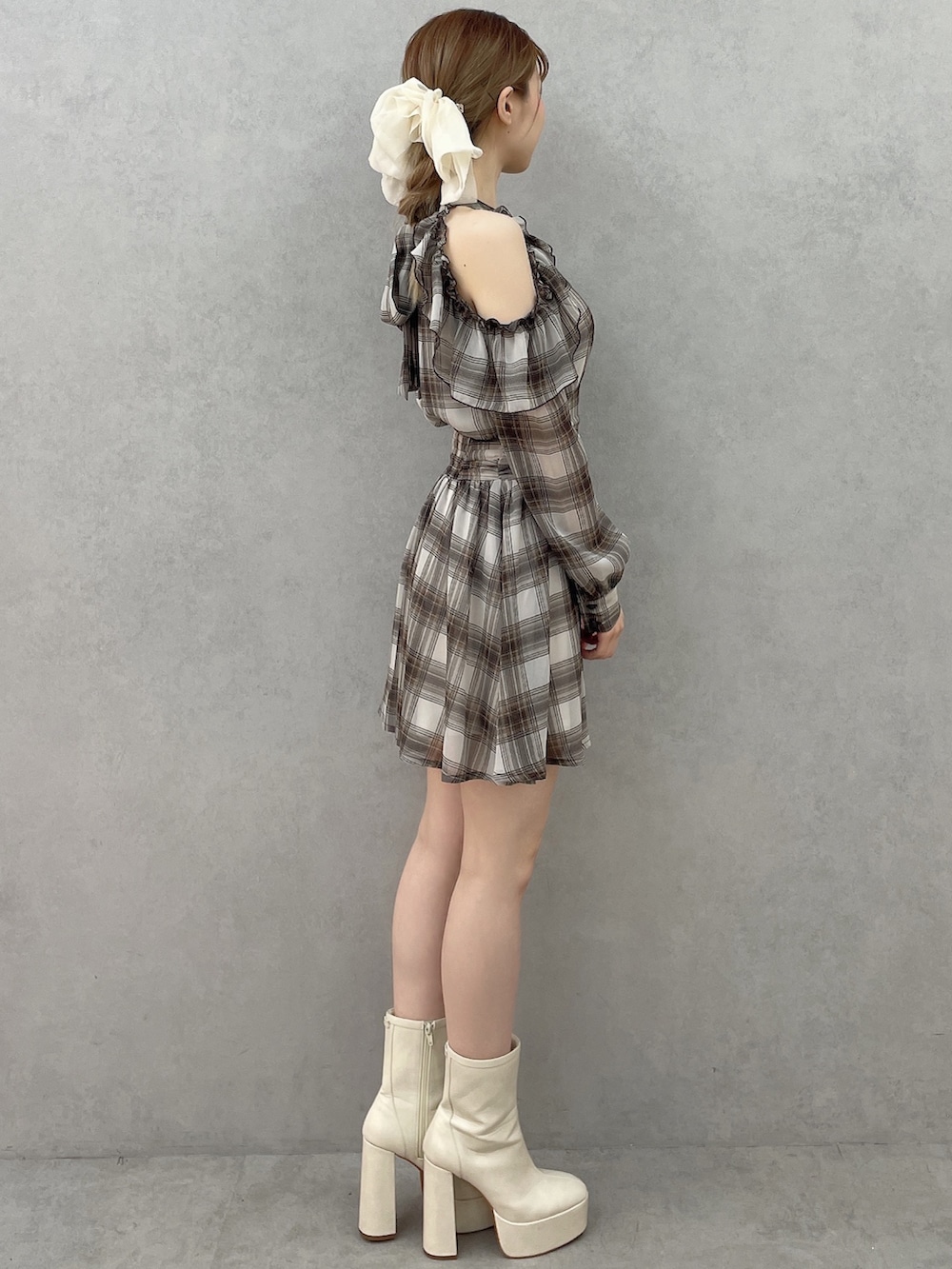 ブラウン系のワンピース、ホワイト系のブーツ、ホワイト系のバレッタ/ヘアクリップを着用したレディースの春コーディネートの4枚目の写真