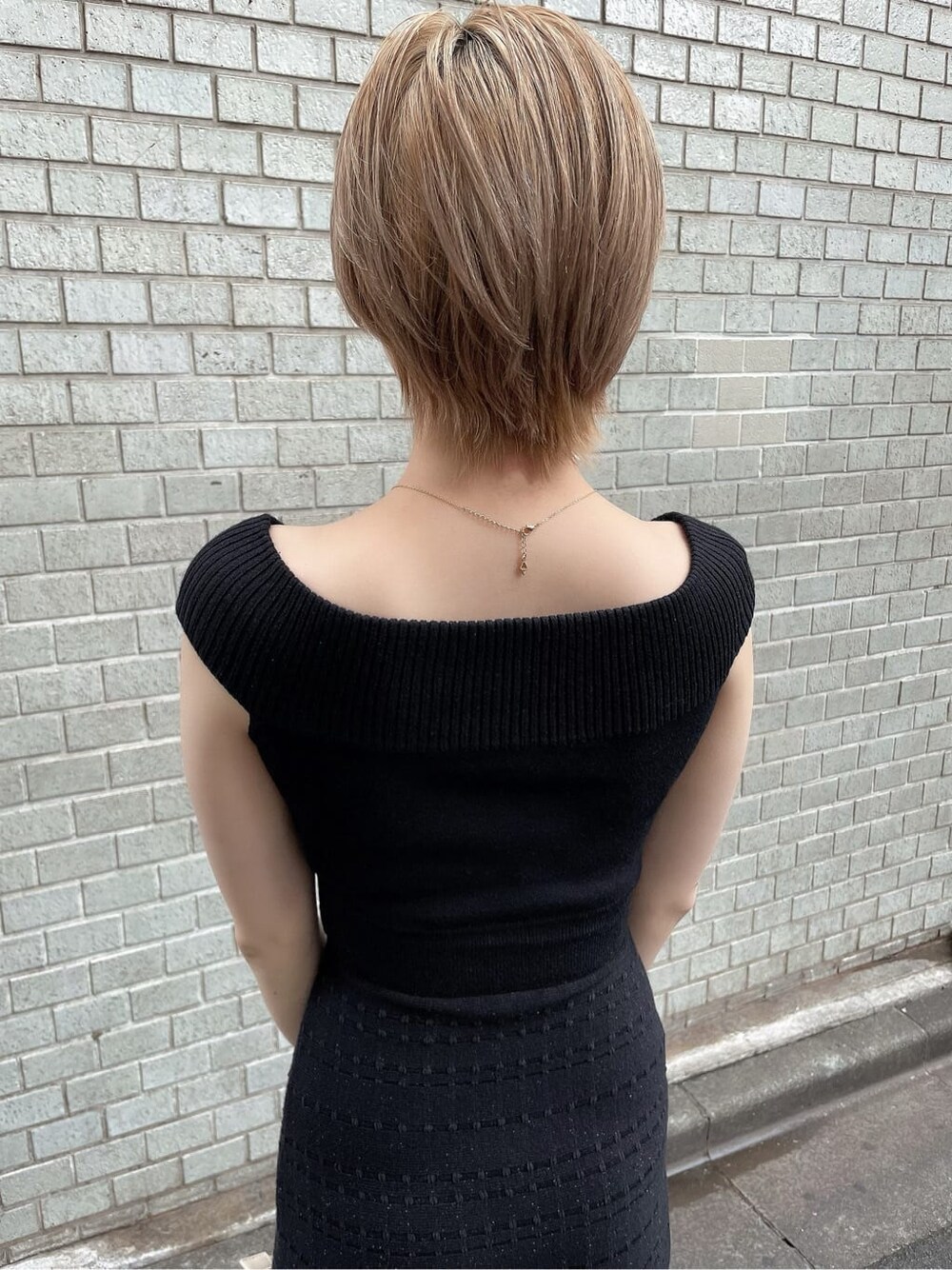 ブラック系のワンピース、ブラック系のサンダル、ベージュ系のハンドバッグを着用したレディースの夏コーディネートの6枚目の写真