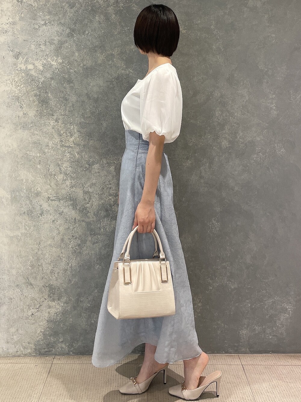 ホワイト系のサンダル、ブルー系のスカート、ホワイト系のTシャツ/カットソーを着用したレディースの春コーディネートの3枚目の写真