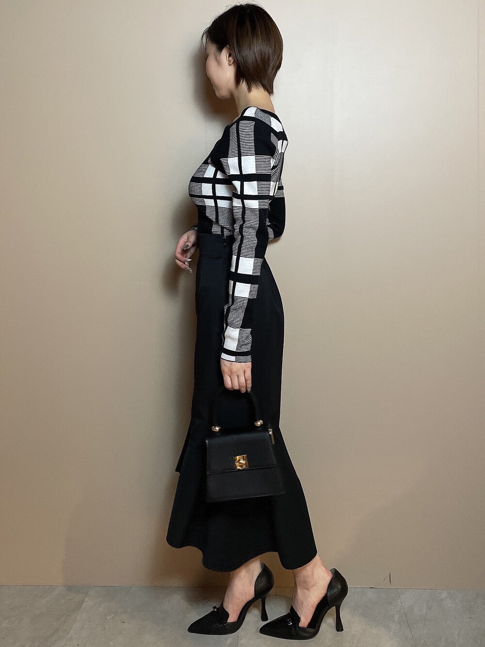 その他のニット/セーター、ブラック系のスカート、ブラック系のパンプスを着用したレディースの冬コーディネートの3枚目の写真