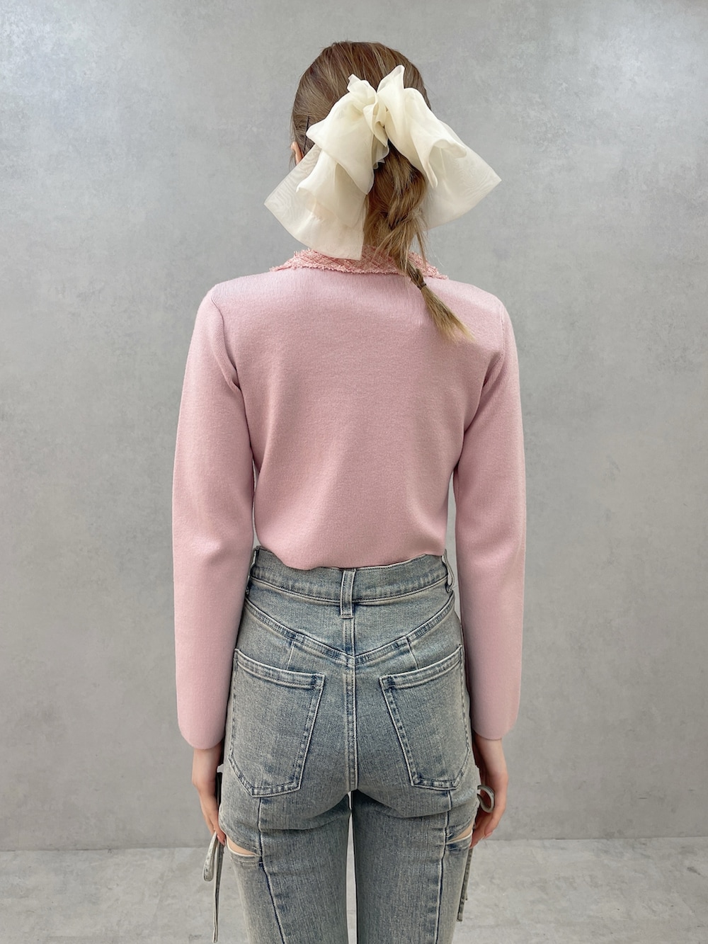 ピンク系のニット/セーター、ブルー系のデニムパンツ、ホワイト系のサンダルを着用したレディースの春コーディネートの6枚目の写真