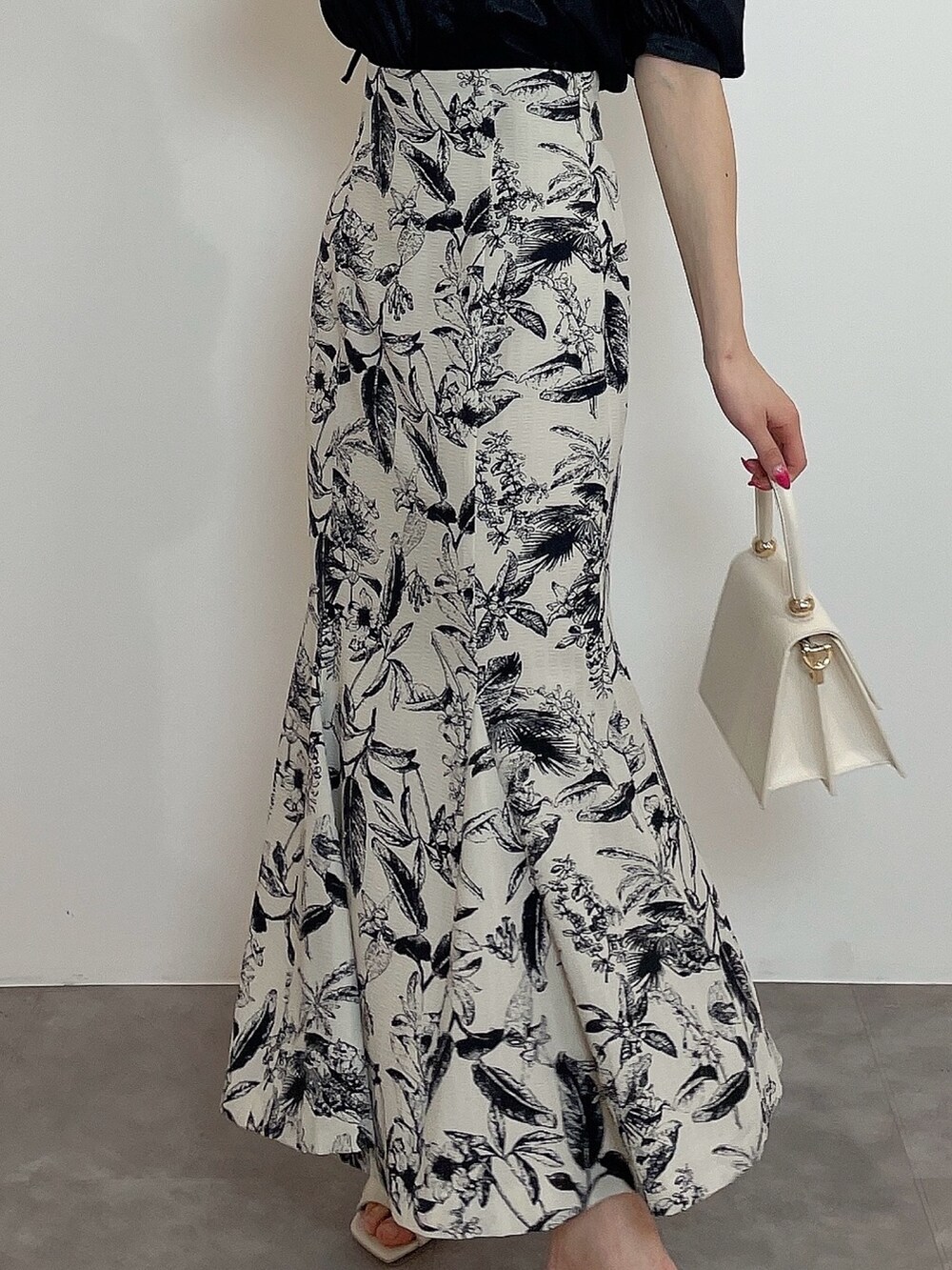 ホワイト系のハンドバッグ、ブラック系のシャツ/ブラウス、その他のスカートを着用したレディースの春コーディネートの6枚目の写真