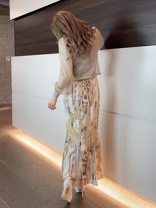 ベージュ系のライダースジャケット、パープル系のスカート、ホワイト系のパンプスを着用したレディースの冬コーディネートの7枚目の写真