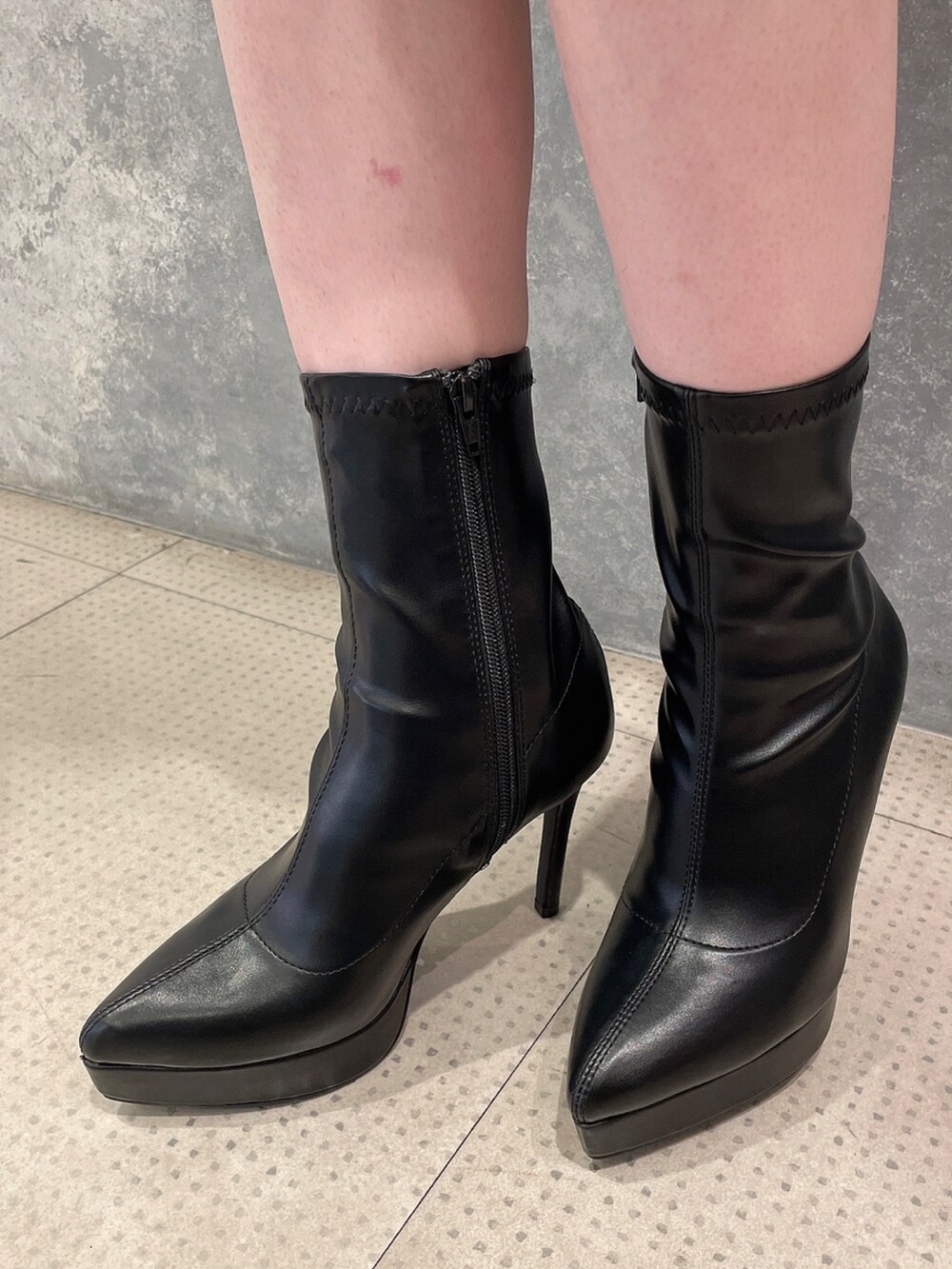 ブラック系のダウンジャケット/コート、パープル系のワンピース、ブラック系のハンドバッグを着用したレディースの秋コーディネートの8枚目の写真