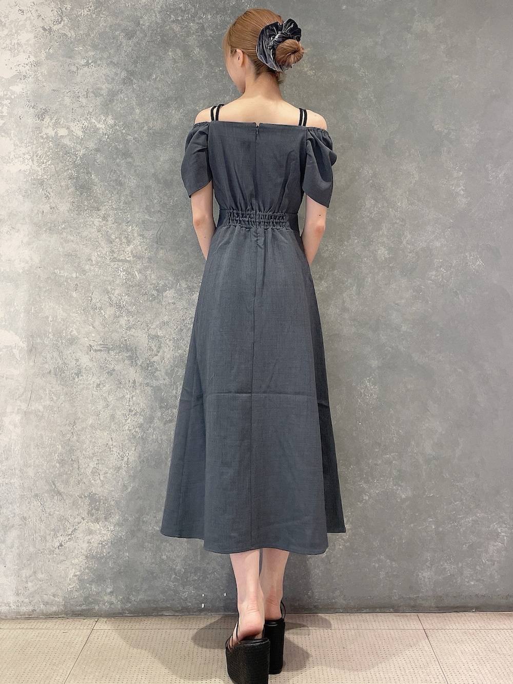 グレー系のワンピース、ブラック系のサンダル、グレー系のシュシュを着用したレディースの夏コーディネートの3枚目の写真