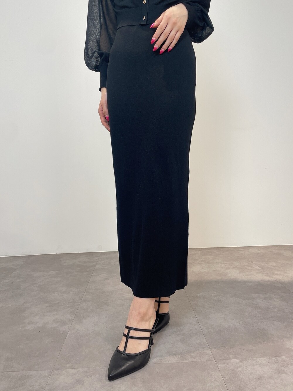 ブラック系のワンピース、ブラック系のパンプスを着用したレディースの冬コーディネートの7枚目の写真