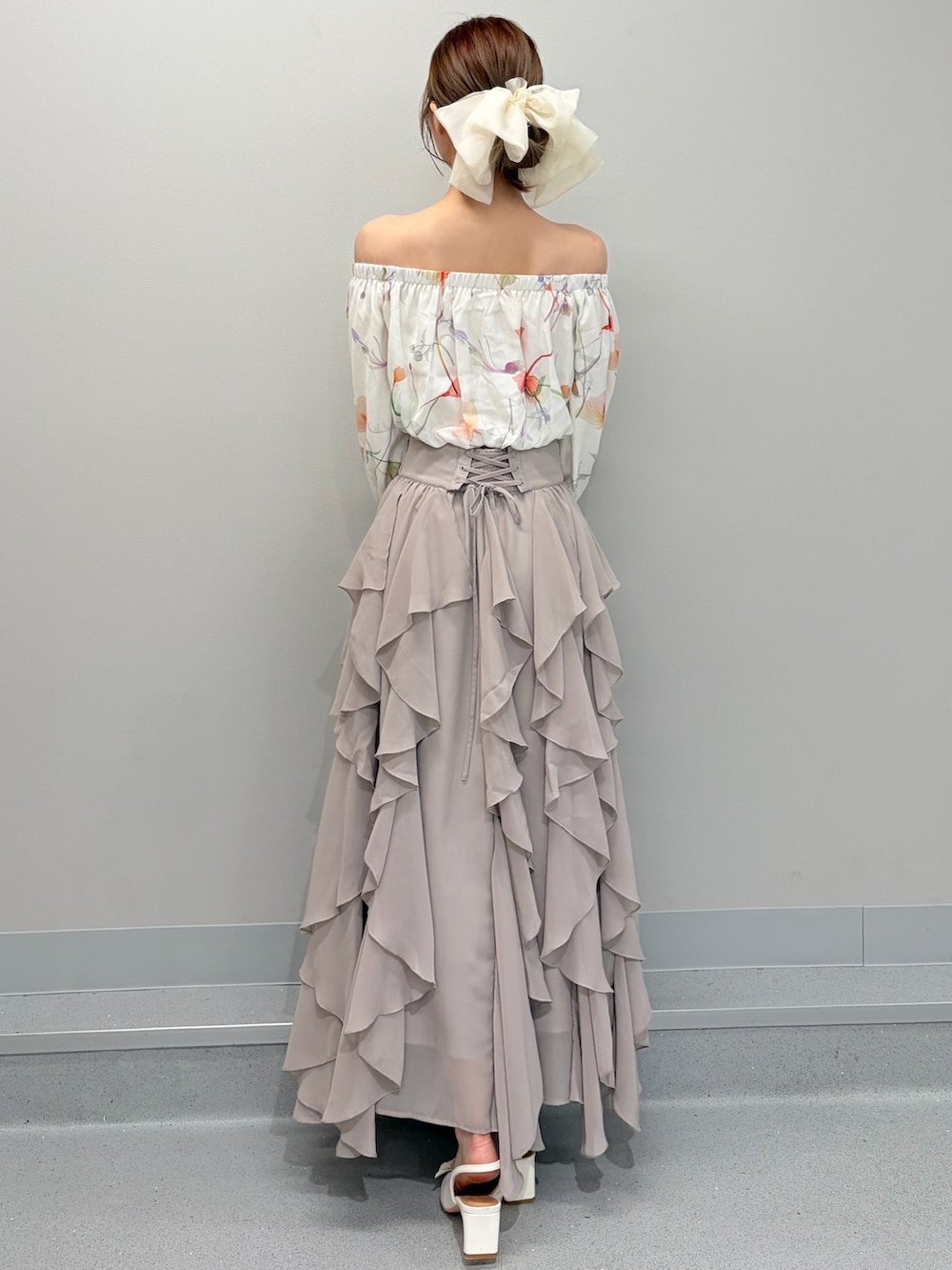 ホワイト系のテーラードジャケット、ホワイト系のシャツ/ブラウス、ベージュ系のスカートを着用したレディースの冬コーディネートの6枚目の写真