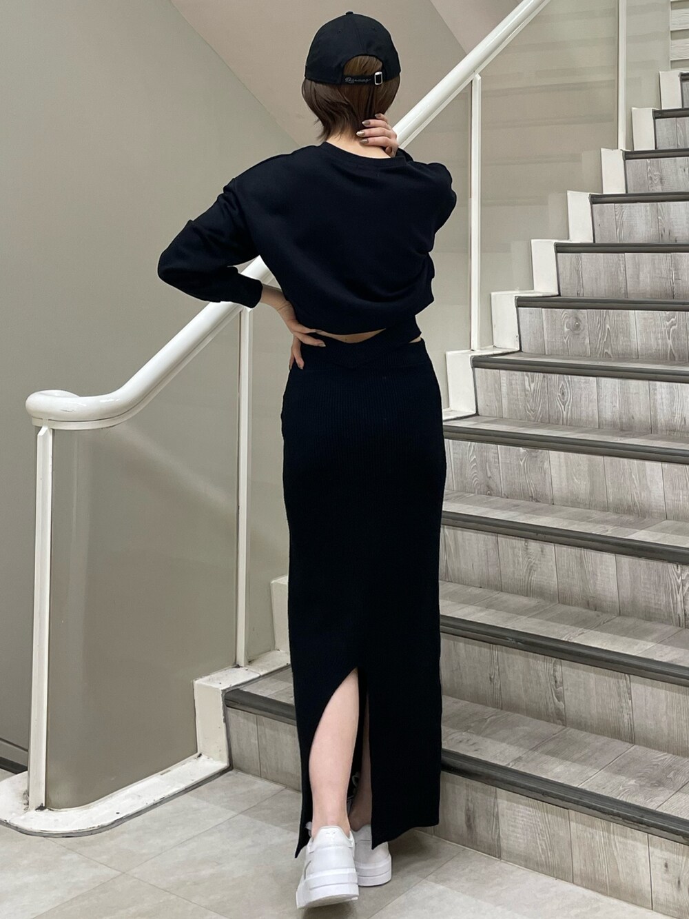 ホワイト系のスニーカー、ブラック系のスウェット、ブラック系のスカートを着用したレディースの冬コーディネートの4枚目の写真