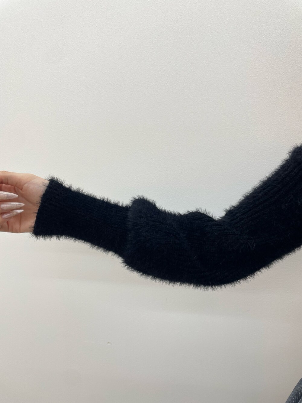 ブラック系のニット/セーター、グレー系のスカート、ブラック系のブーツを着用したレディースの秋コーディネートの8枚目の写真