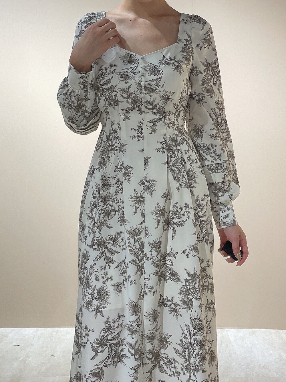 ホワイト系のダウンジャケット/コート、ホワイト系のパンプス、ベージュ系のワンピースを着用したレディースの秋コーディネートの9枚目の写真