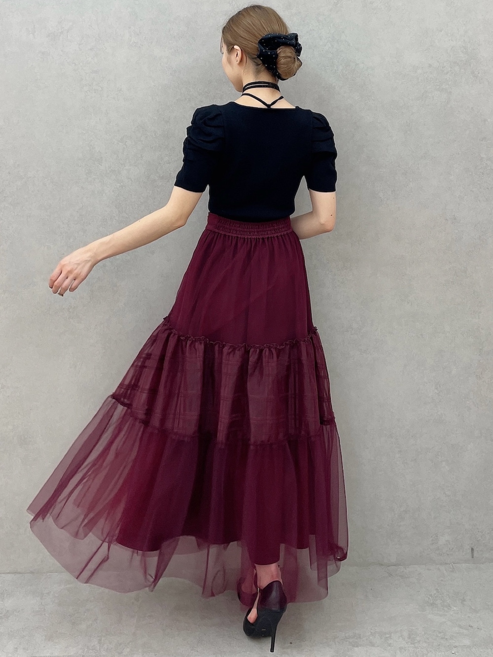 ブラック系のニット/セーター、レッド系のスカート、ブラック系のパンプスを着用したレディースの夏コーディネートの4枚目の写真