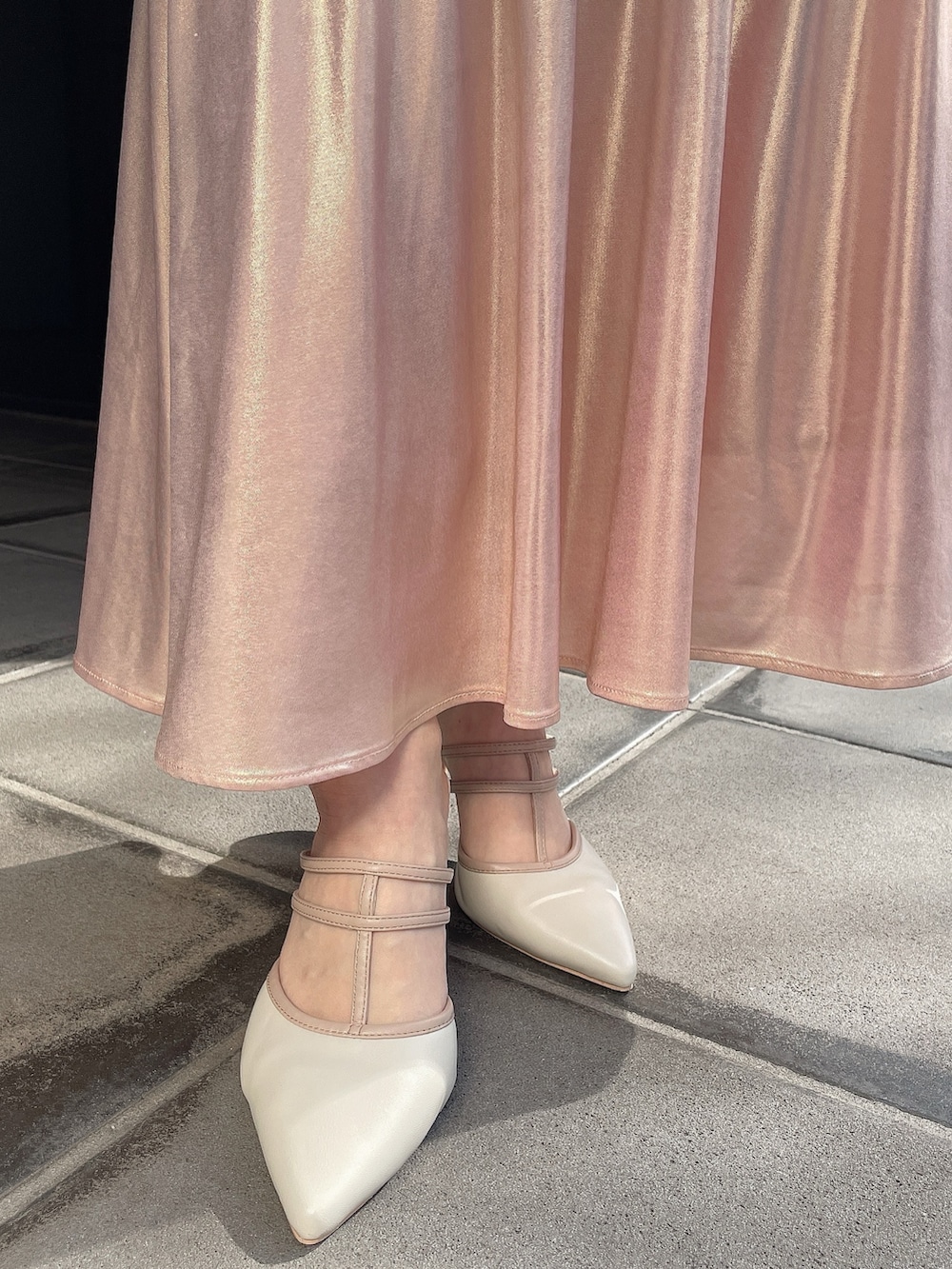 オレンジ系のニット/セーター、ゴールド系のスカート、ピンク系のハンドバッグを着用したレディースの春コーディネートの8枚目の写真