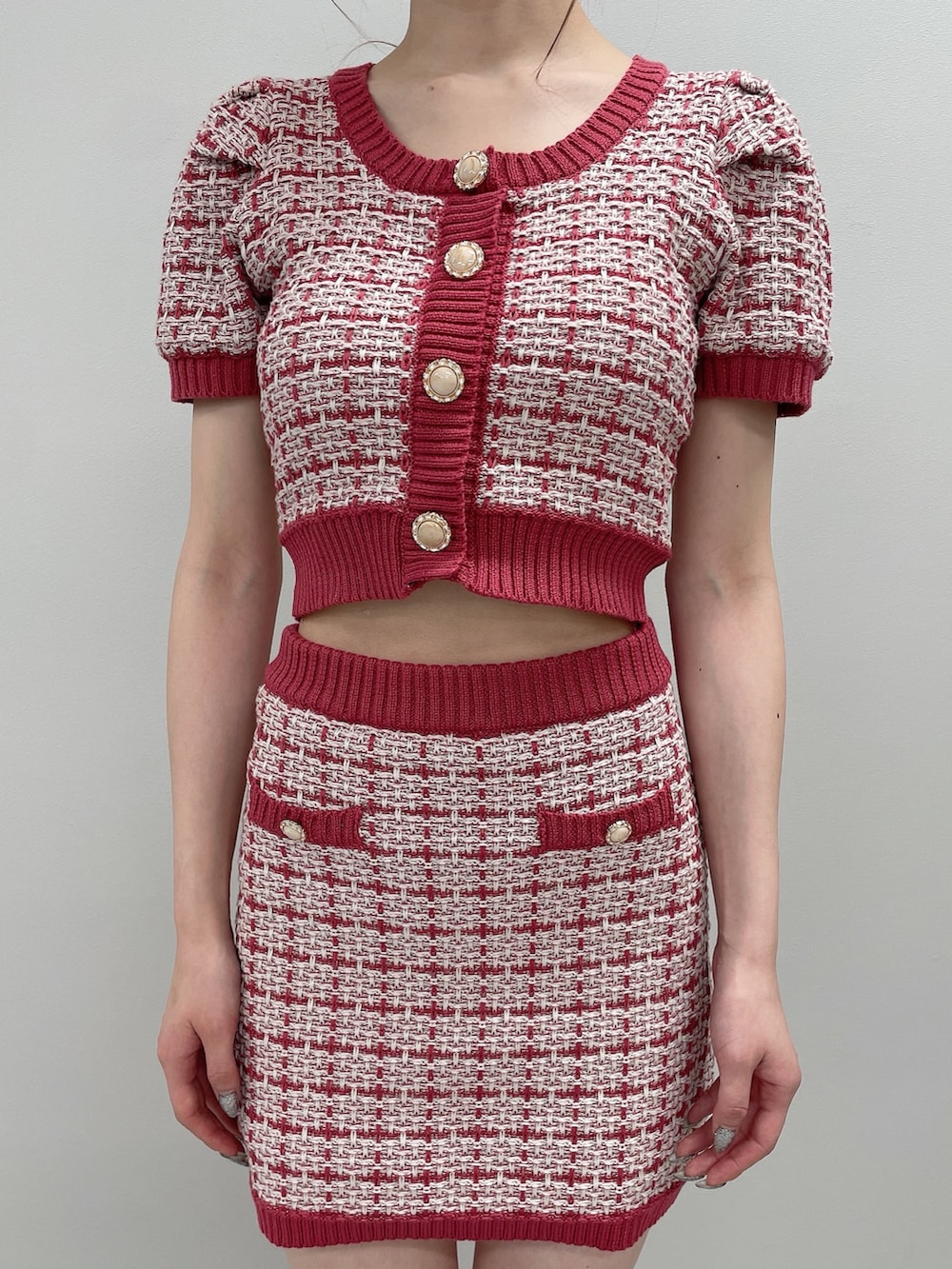 ピンク系のニット/セーター、ピンク系のスカート、ベージュ系のサンダルを着用したレディースの春コーディネートの5枚目の写真