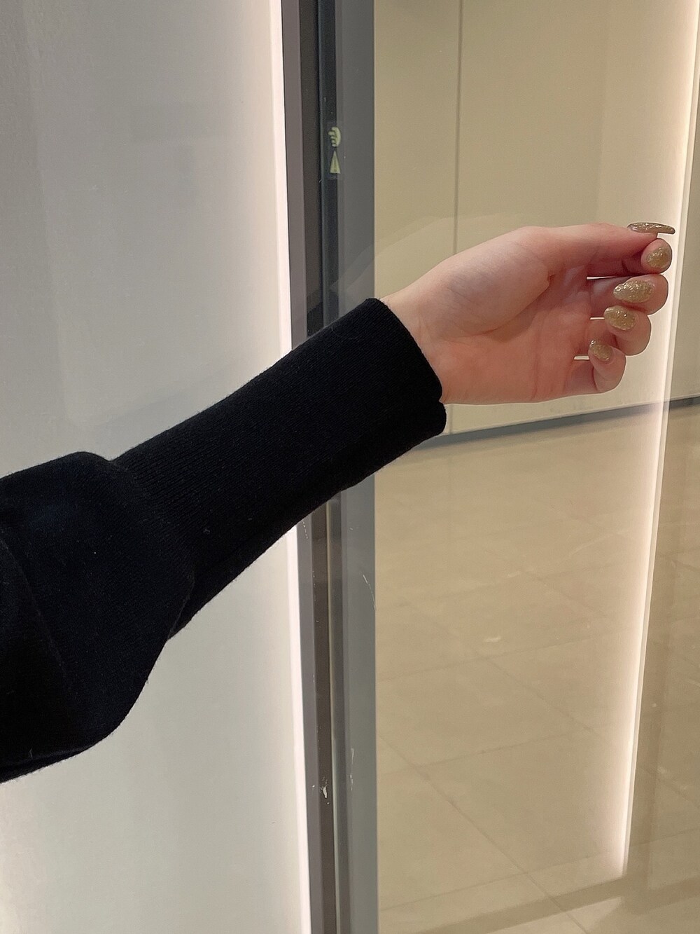 ブラック系のニット/セーター、ブラック系のスカート、ブラック系のパンプスを着用したレディースの冬コーディネートの7枚目の写真