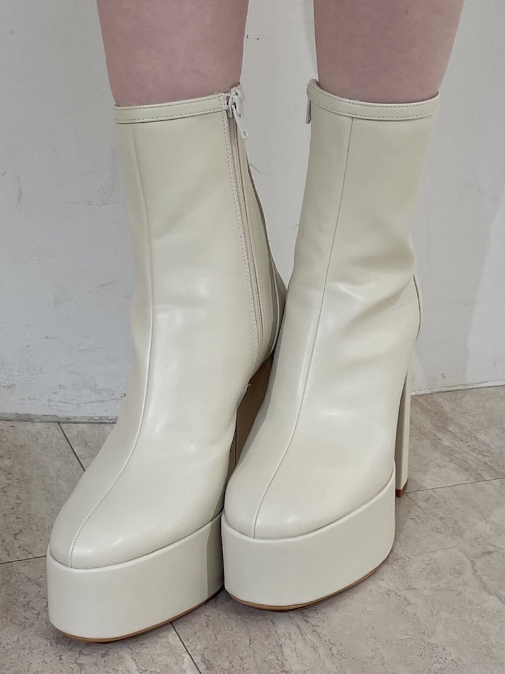 オレンジ系のワンピース、ホワイト系のブーツ、ホワイト系のバレッタ/ヘアクリップを着用したレディースの冬コーディネートの8枚目の写真