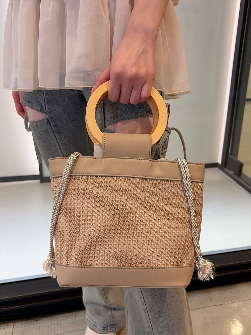 ホワイト系のシャツ/ブラウス、ブルー系のデニムパンツ、ベージュ系のハンドバッグを着用したレディースの夏コーディネートの6枚目の写真