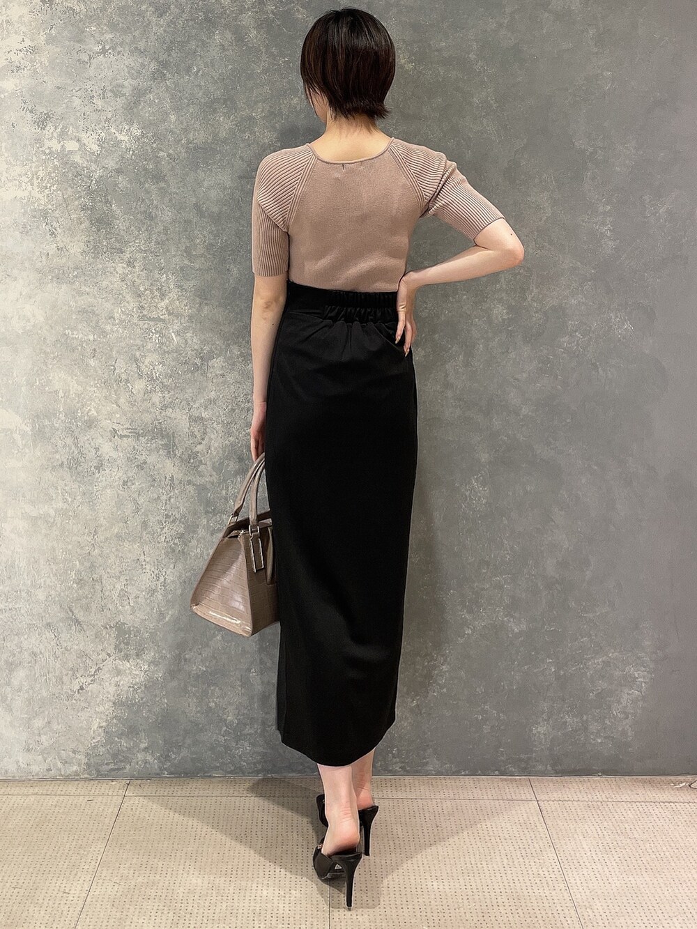 ブラック系のサンダル、ベージュ系のニット/セーター、ブラック系のスカートを着用したレディースの夏コーディネートの4枚目の写真