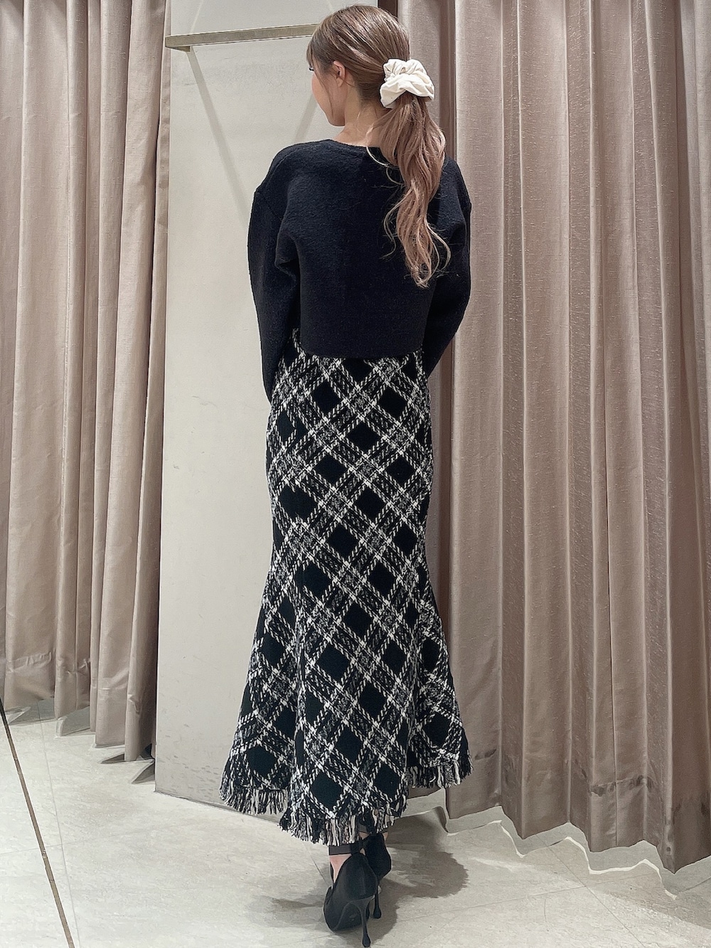 グレー系のカーディガン/ボレロ、ブラック系のワンピース、ブラック系のパンプスを着用したレディースの秋コーディネートの3枚目の写真