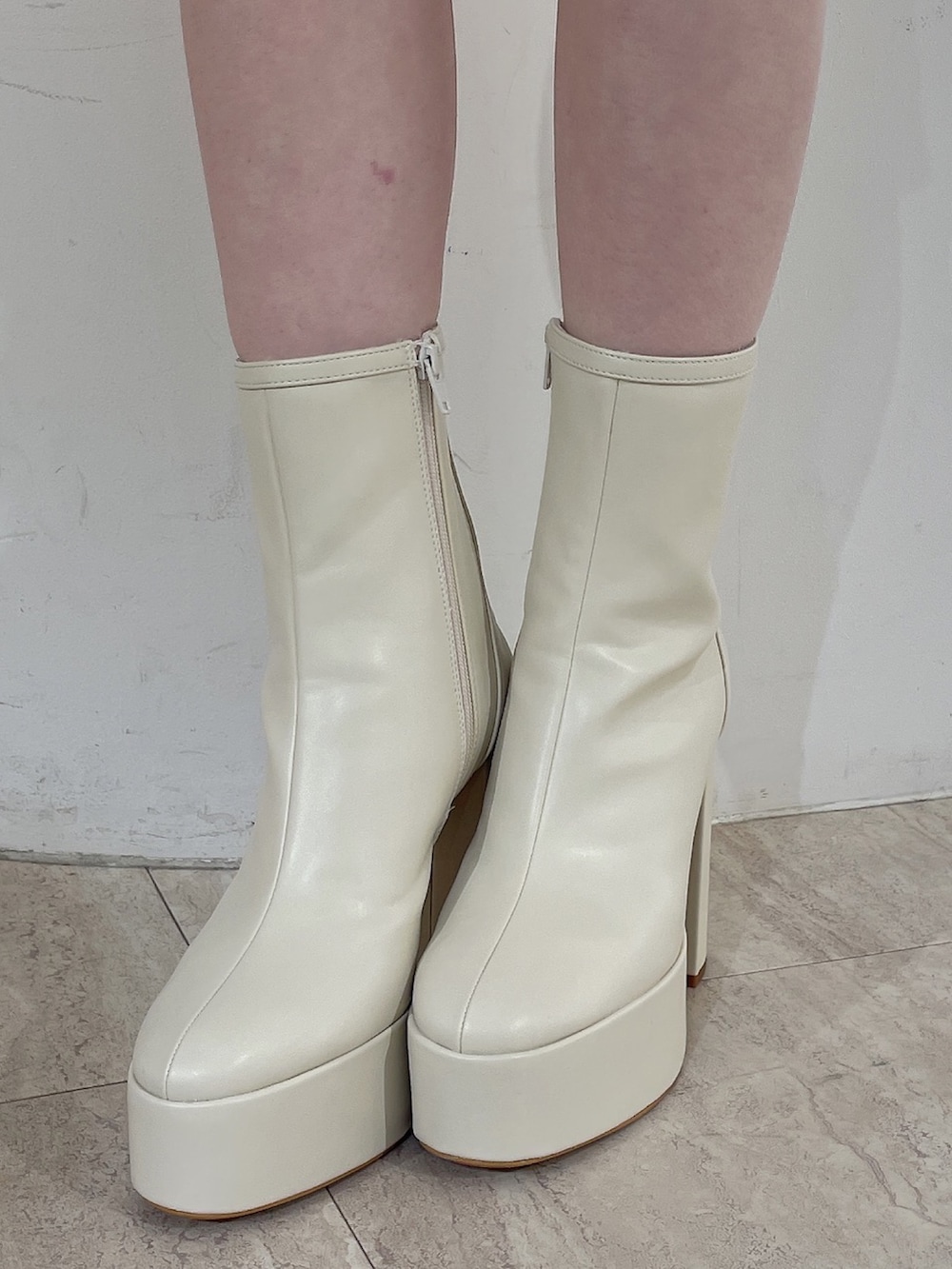 ブルー系のテーラードジャケット、レッド系のニット/セーター、ホワイト系のスカートを着用したレディースの冬コーディネートの10枚目の写真