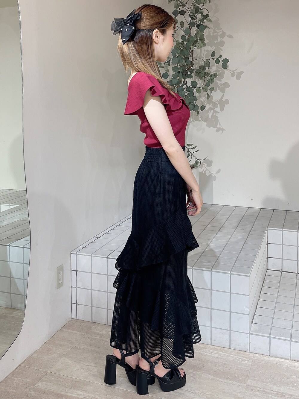 ブラック系のサンダル、レッド系のニット/セーター、ブラック系のスカートを着用したレディースの夏コーディネートの2枚目の写真