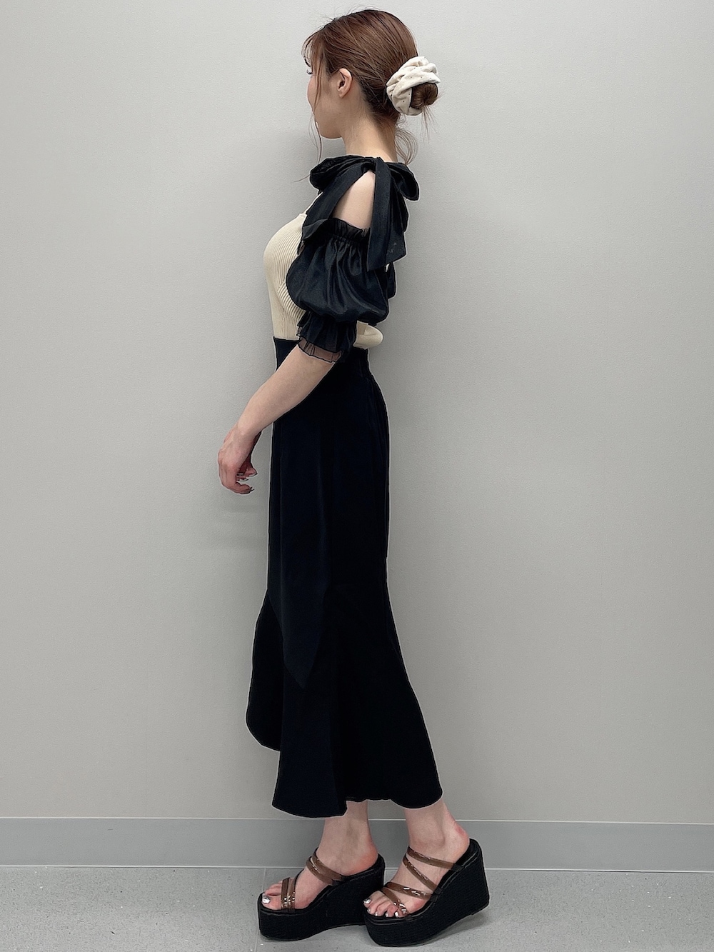 その他のニット/セーター、ブラック系のスカート、ブラック系のサンダルを着用したレディースの春コーディネートの2枚目の写真