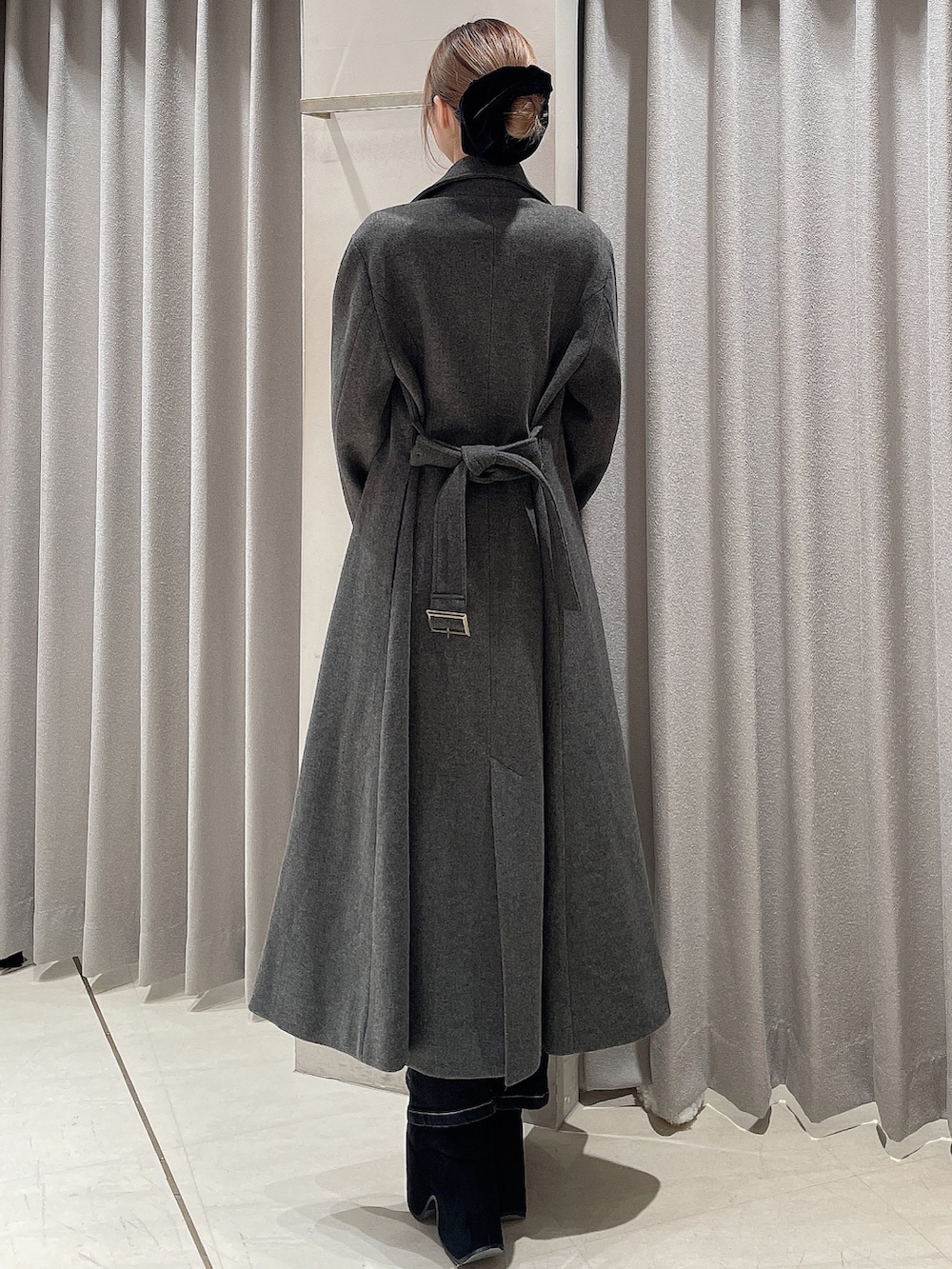 レッド系のニット/セーター、ブラック系のデニムパンツ、ブラック系のブーツを着用したレディースの秋コーディネートの6枚目の写真