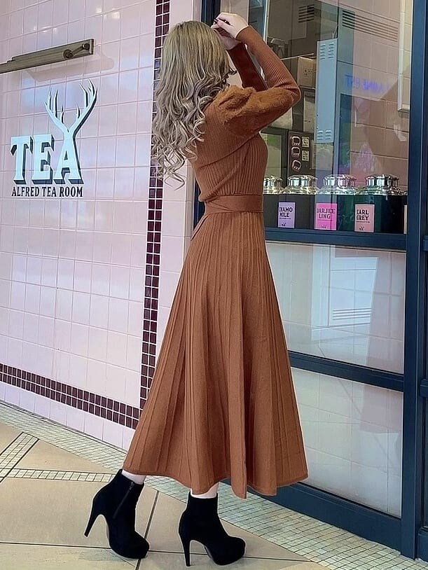 ブラック系のブーツ、オレンジ系のワンピースを着用したレディースの冬コーディネートの3枚目の写真