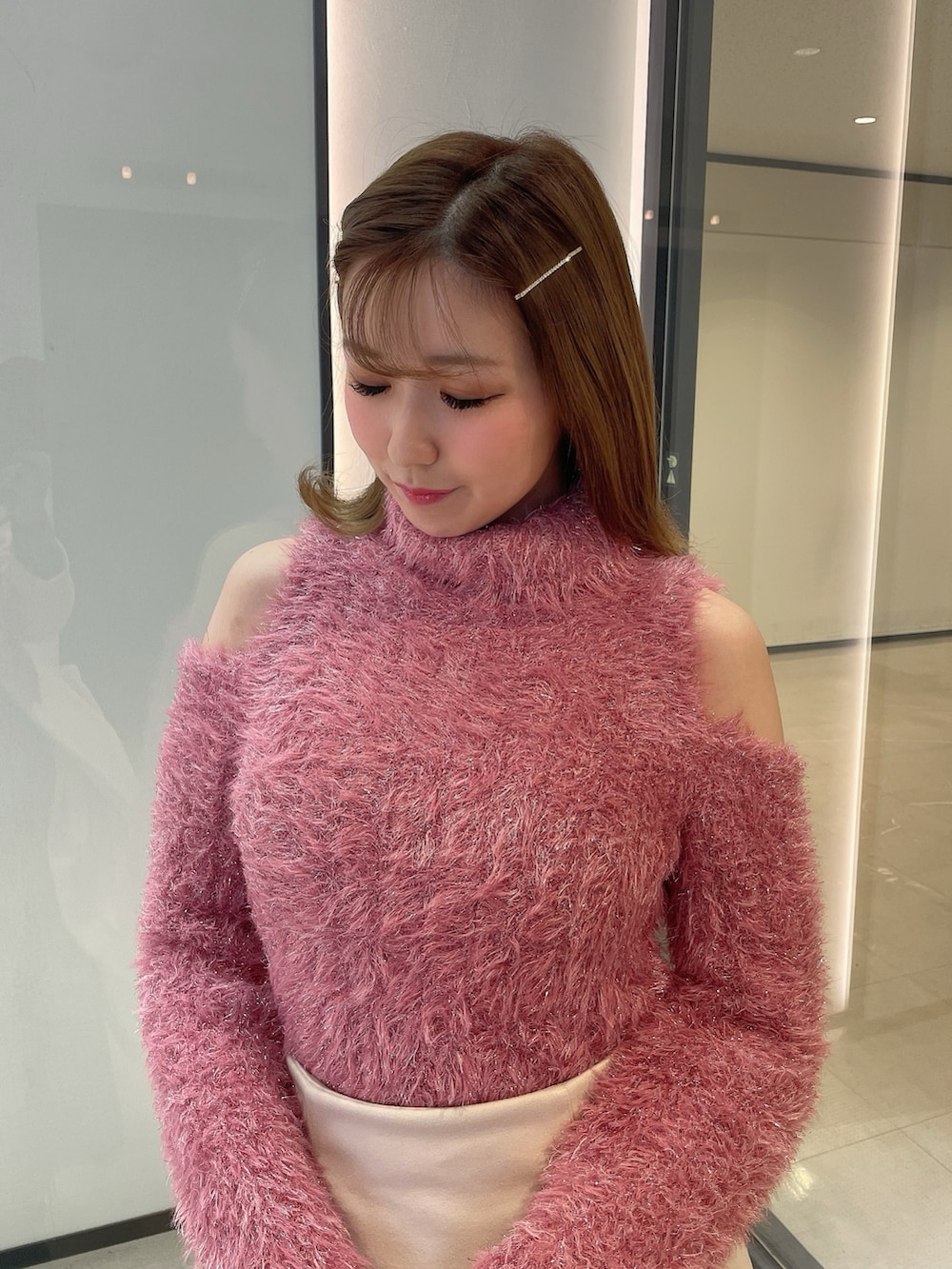 ピンク系のニット/セーター、ホワイト系のスカート、ブラウン系のブーツを着用したレディースの冬コーディネートの5枚目の写真