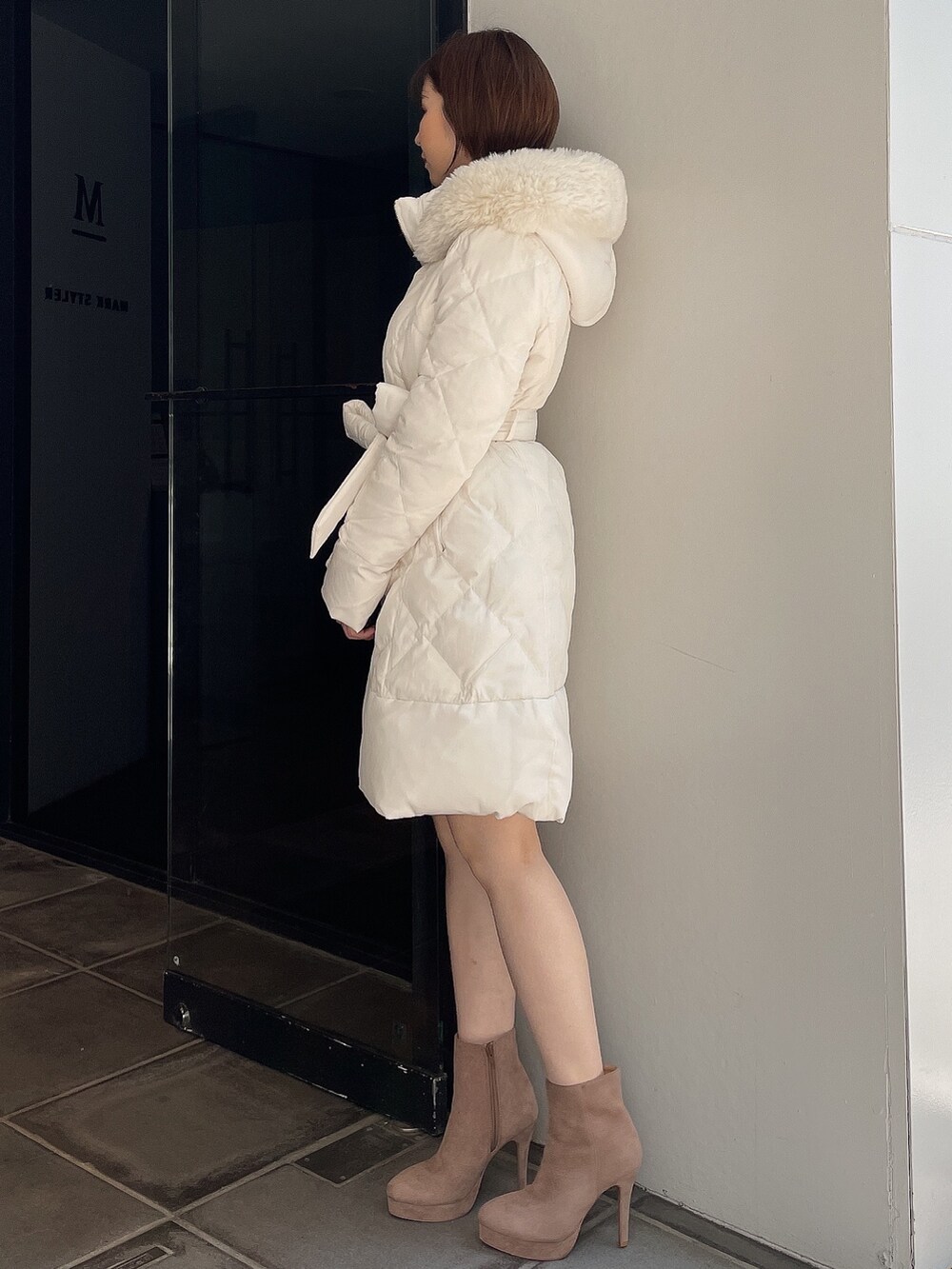 ベージュ系のブーツ、ホワイト系のダウンジャケット/コートを着用したレディースの夏コーディネートの4枚目の写真