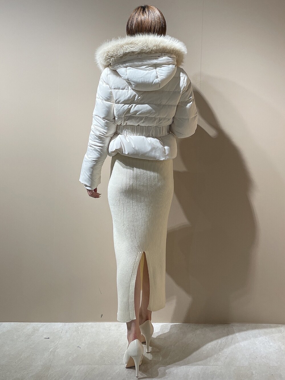 ホワイト系のワンピース、ホワイト系のダウンジャケット/コート、ホワイト系のパンプスを着用したレディースの秋コーディネートの7枚目の写真