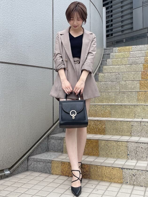 ベージュ系のテーラードジャケット、ブラック系のハンドバッグ、ベージュ系のその他パンツを着用したレディースの夏コーディネートの2枚目の写真