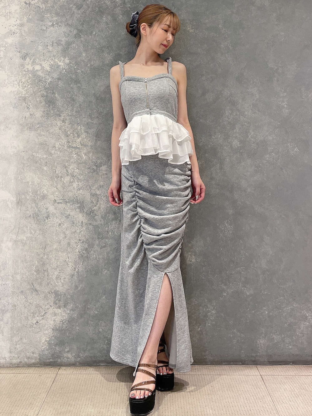 グレー系のキャミソール、グレー系のスカート、ブラック系のサンダルを着用したレディースの夏コーディネートの2枚目の写真