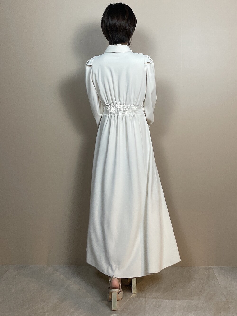 ホワイト系のシャツワンピース、ベージュ系のサンダルを着用したレディースの夏コーディネートの5枚目の写真