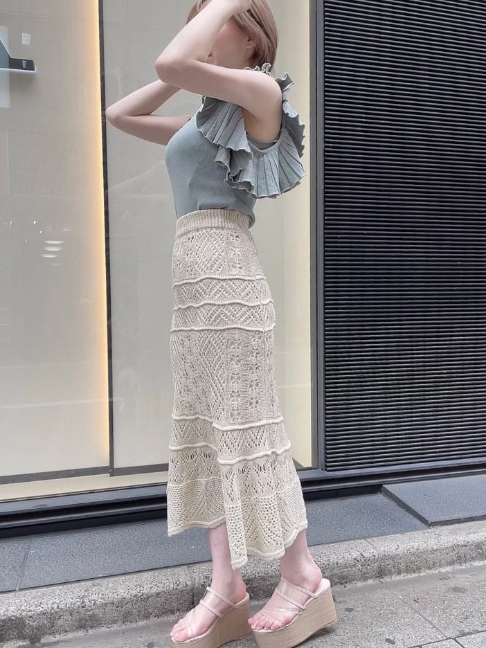 ベージュ系のスカート、ホワイト系のサンダル、グリーン系のニット/セーターを着用したレディースの春コーディネートの4枚目の写真