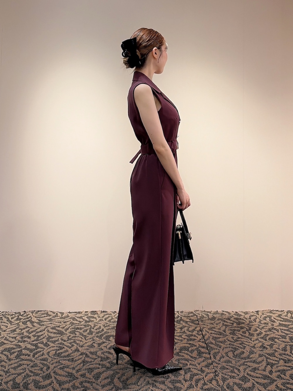 レッド系のワンピース、ブラック系のハンドバッグ、ブラック系のバレッタ/ヘアクリップを着用したレディースの夏コーディネートの2枚目の写真