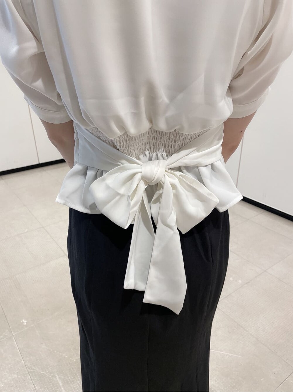 ホワイト系のパンプス、ブラウン系のショルダーバッグ、ホワイト系のシャツ/ブラウスを着用したレディースの夏コーディネートの5枚目の写真