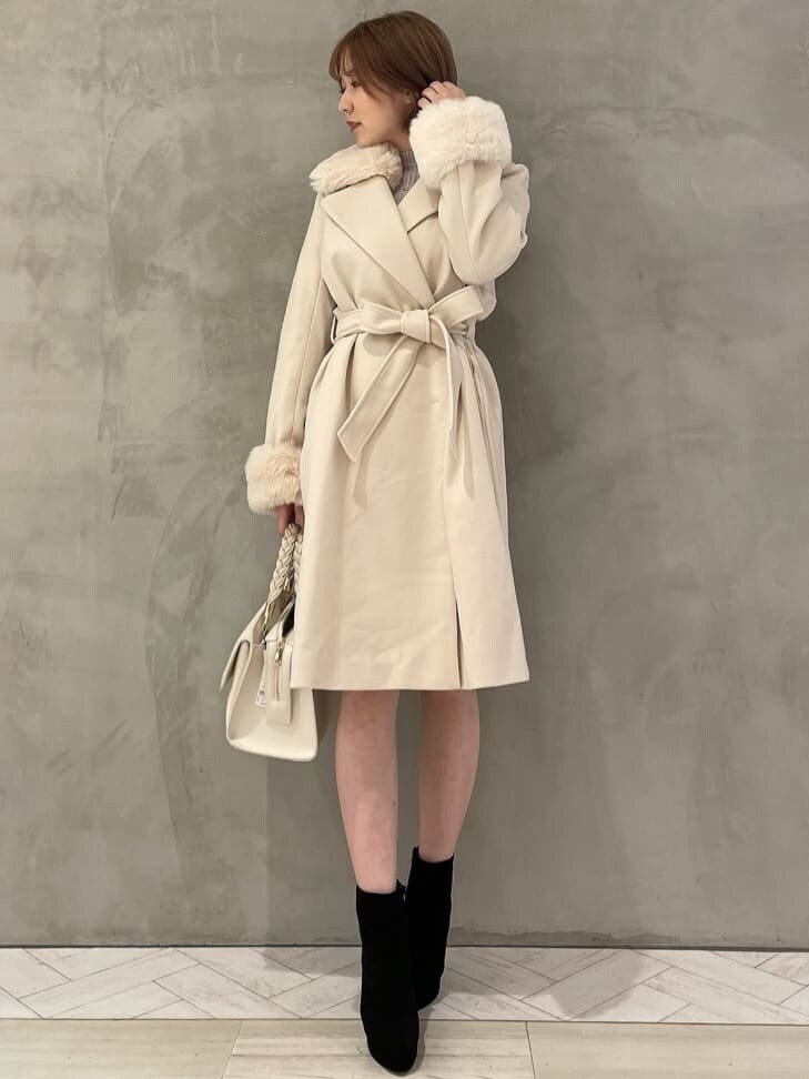 ブラック系のブーツ、ホワイト系のハンドバッグ、ホワイト系のその他アウターを着用したレディースの秋コーディネートの2枚目の写真