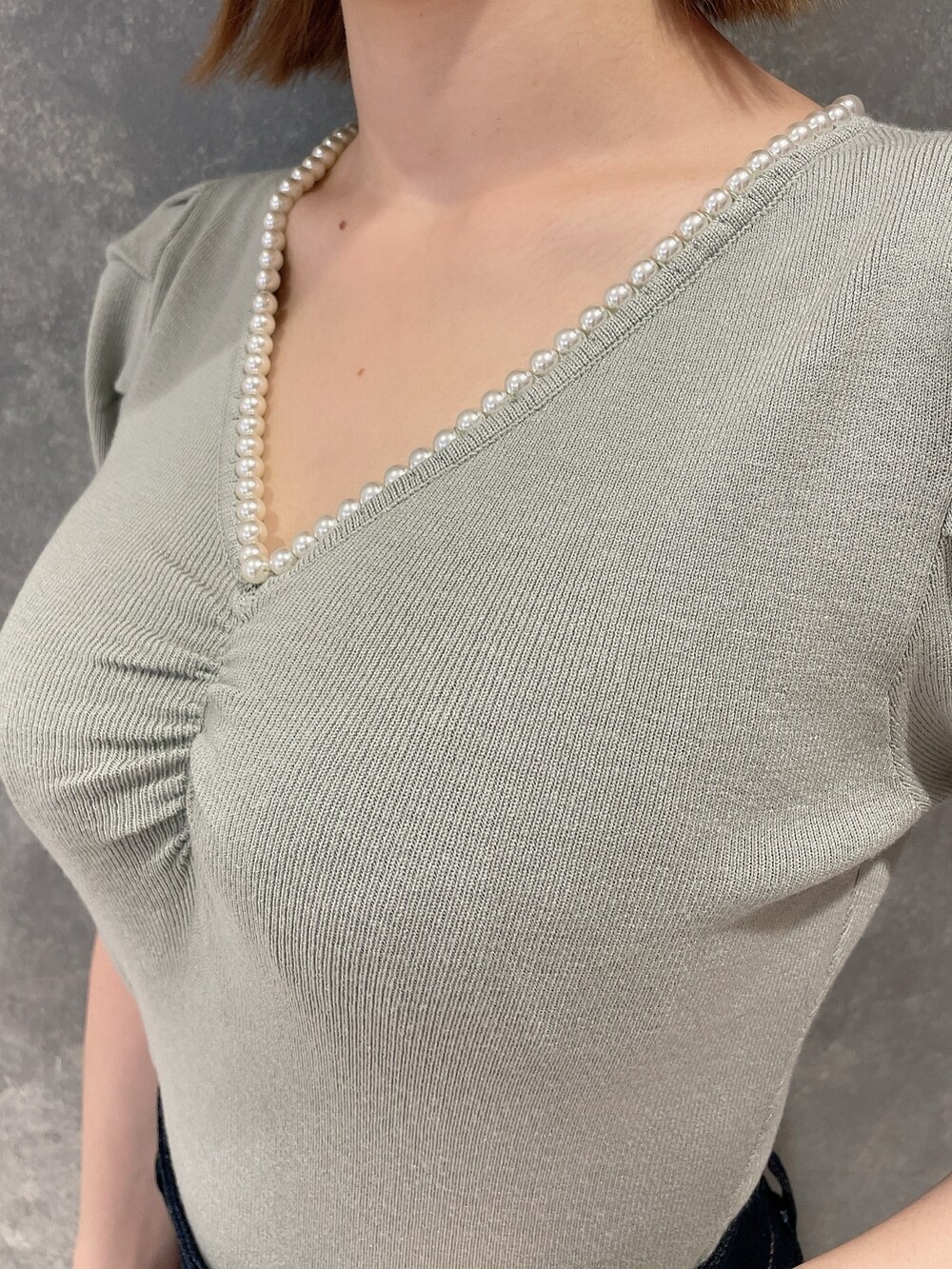 グリーン系のニット/セーター、ブルー系のスカート、ホワイト系のサンダルを着用したレディースの春コーディネートの5枚目の写真