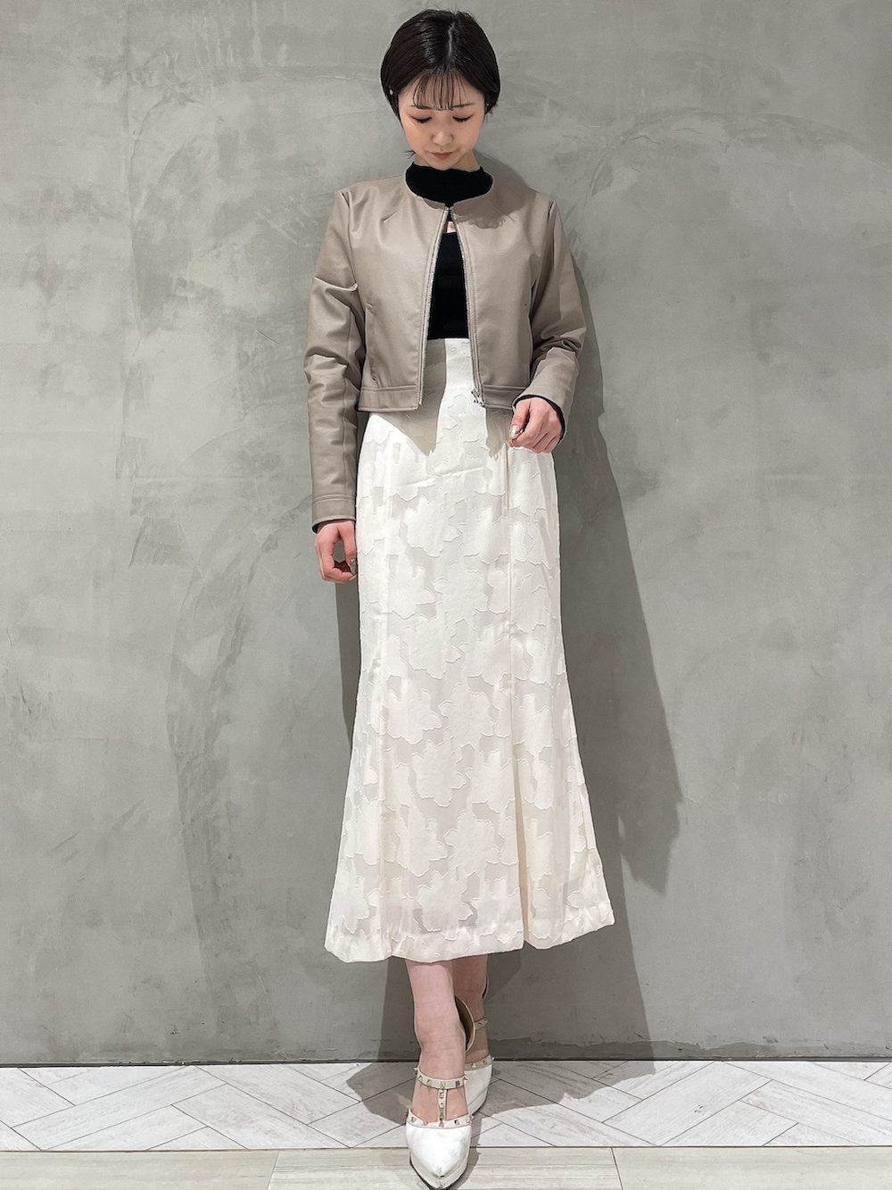 ホワイト系のパンプス、ホワイト系のスカート、ブラック系のニット/セーターを着用したレディースの冬コーディネートの4枚目の写真