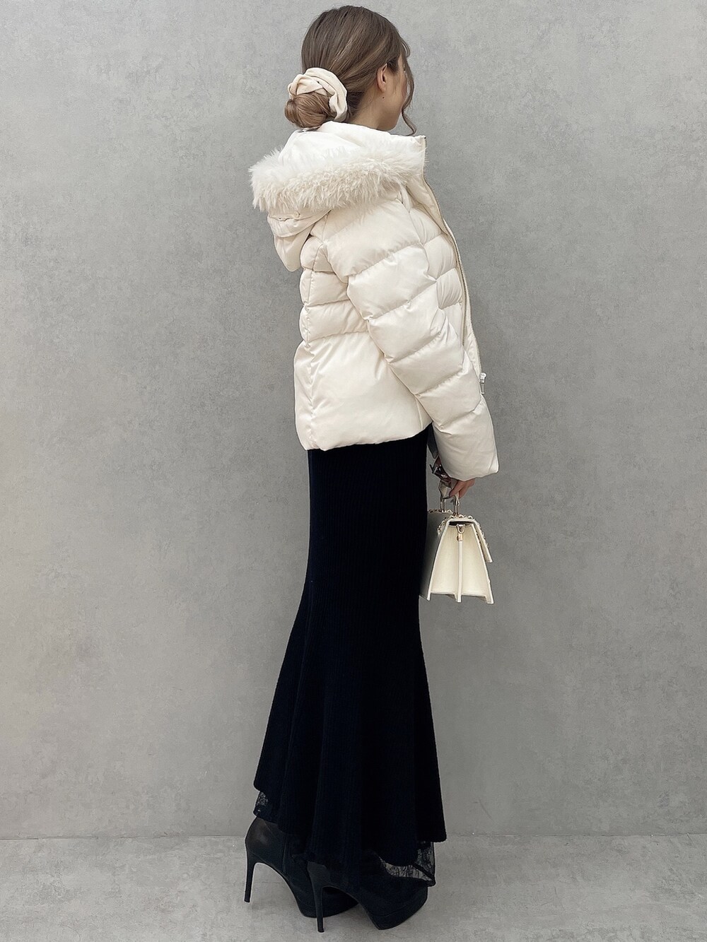 ホワイト系のダウンジャケット/コート、ブラック系のワンピース、ブラック系のブーツを着用したレディースの秋コーディネートの2枚目の写真