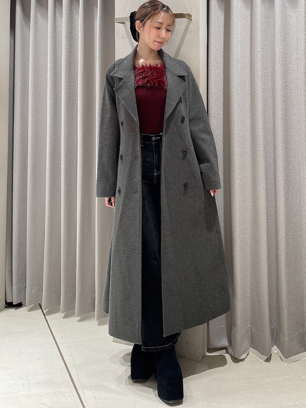 レッド系のニット/セーター、ブラック系のデニムパンツ、ブラック系のブーツを着用したレディースの秋コーディネートの4枚目の写真