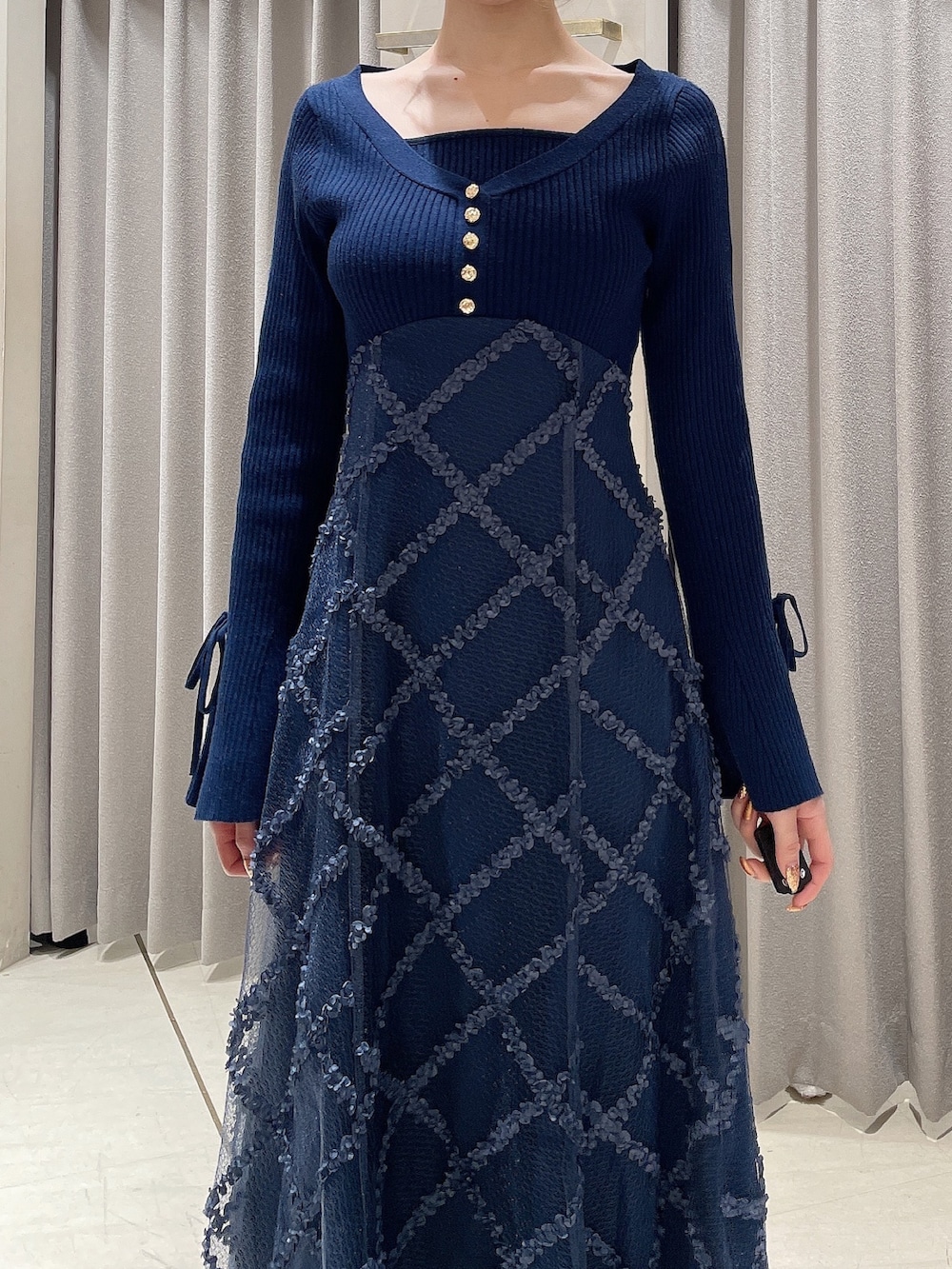 ブルー系のワンピース、ブラック系のブーツ、ブラック系のシュシュを着用したレディースの秋コーディネートの6枚目の写真