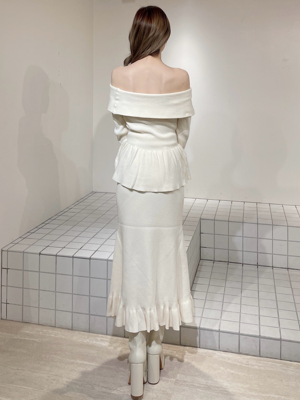 ホワイト系のニット/セーター、ホワイト系のスカート、ホワイト系のブーツを着用したレディースの冬コーディネートの4枚目の写真