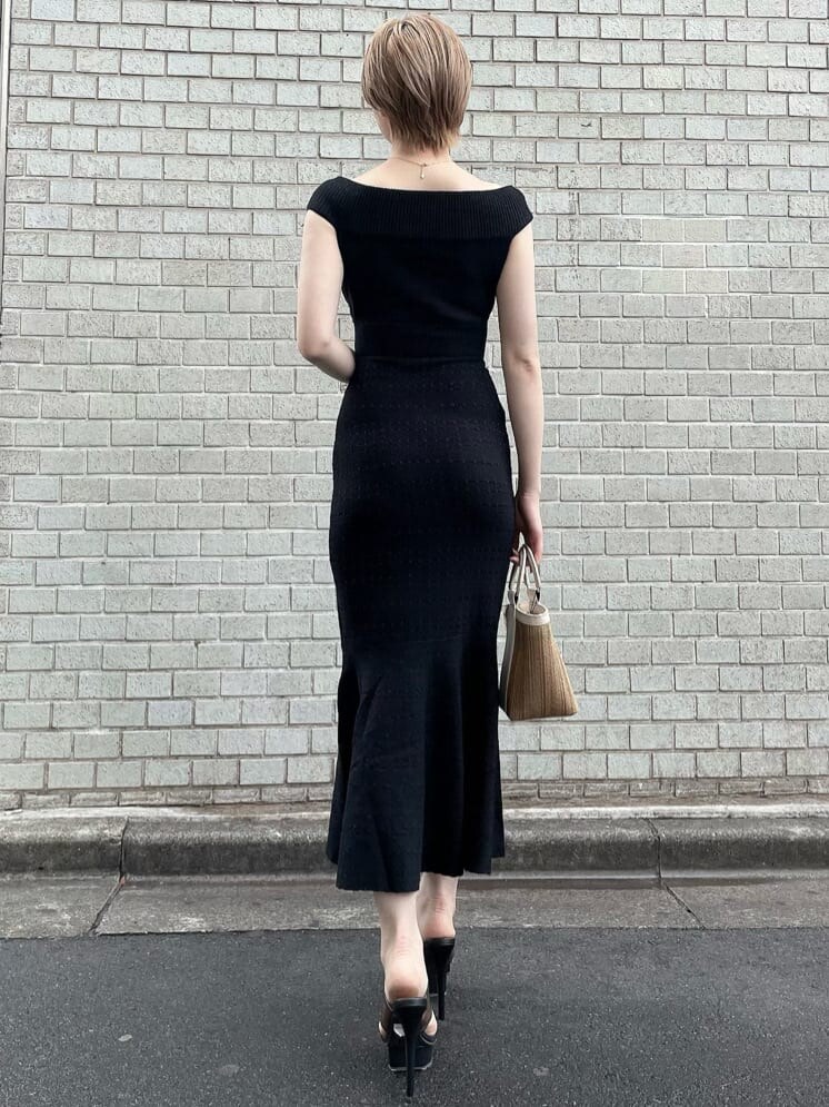 ブラック系のワンピース、ブラック系のサンダル、ベージュ系のハンドバッグを着用したレディースの夏コーディネートの3枚目の写真