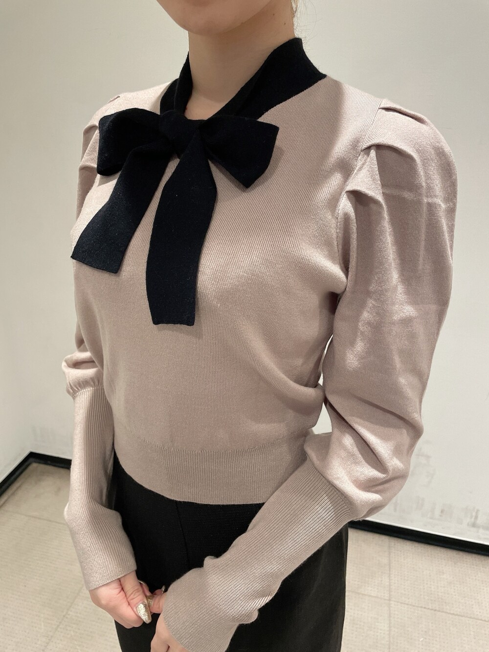 ベージュ系のニット/セーター、ブラック系のスカート、ブラック系のブーツを着用したレディースの冬コーディネートの5枚目の写真