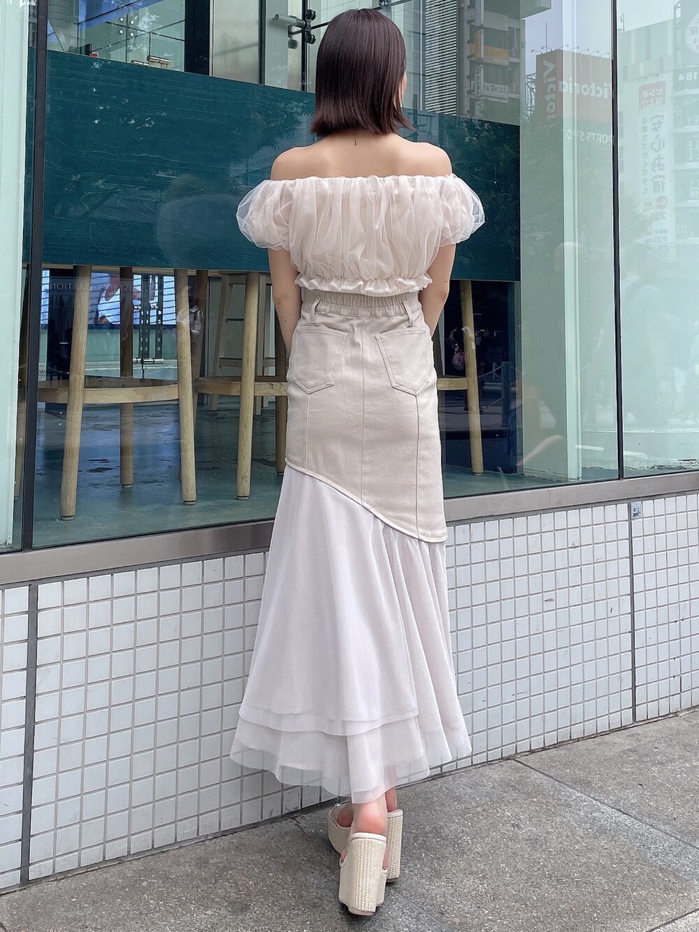 ホワイト系のシャツ/ブラウス、ベージュ系のスカート、ホワイト系のサンダルを着用したレディースの春コーディネートの4枚目の写真