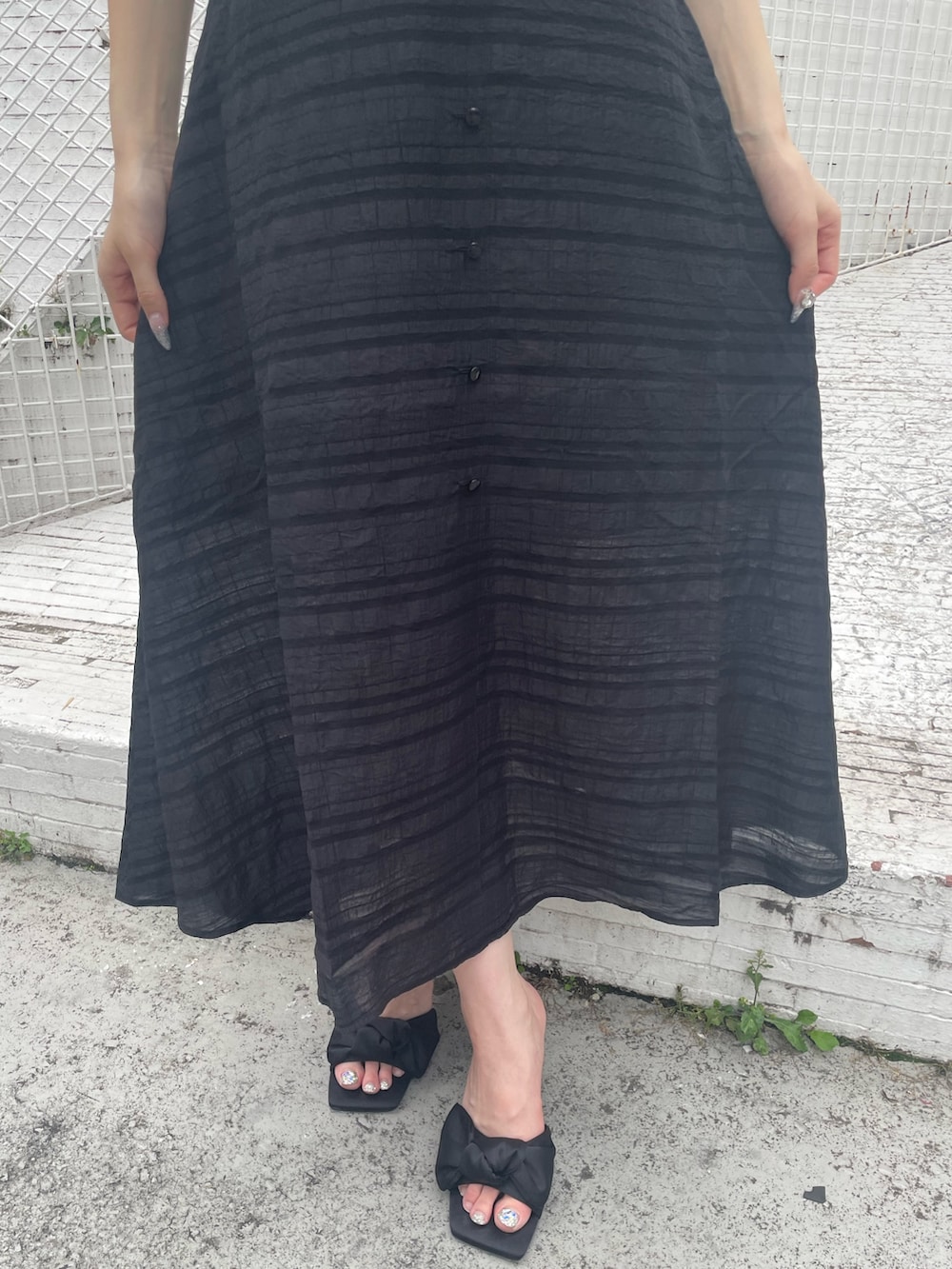 ブラック系のワンピース、ブラック系のサンダルを着用したレディースの夏コーディネートの6枚目の写真