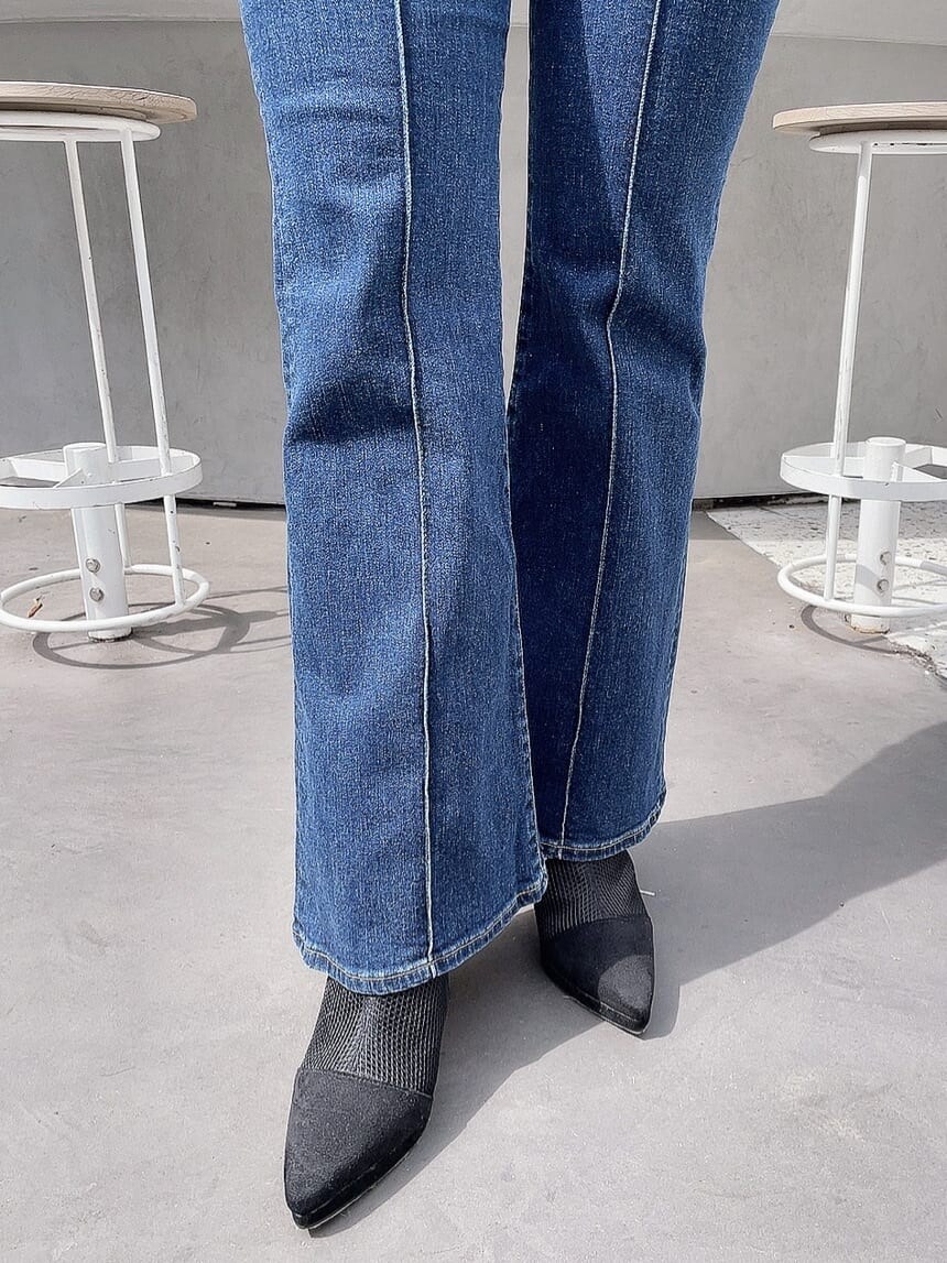 ブルー系のデニムパンツ、ブラック系のブーツ、グリーン系のニット/セーターを着用したレディースの春コーディネートの6枚目の写真
